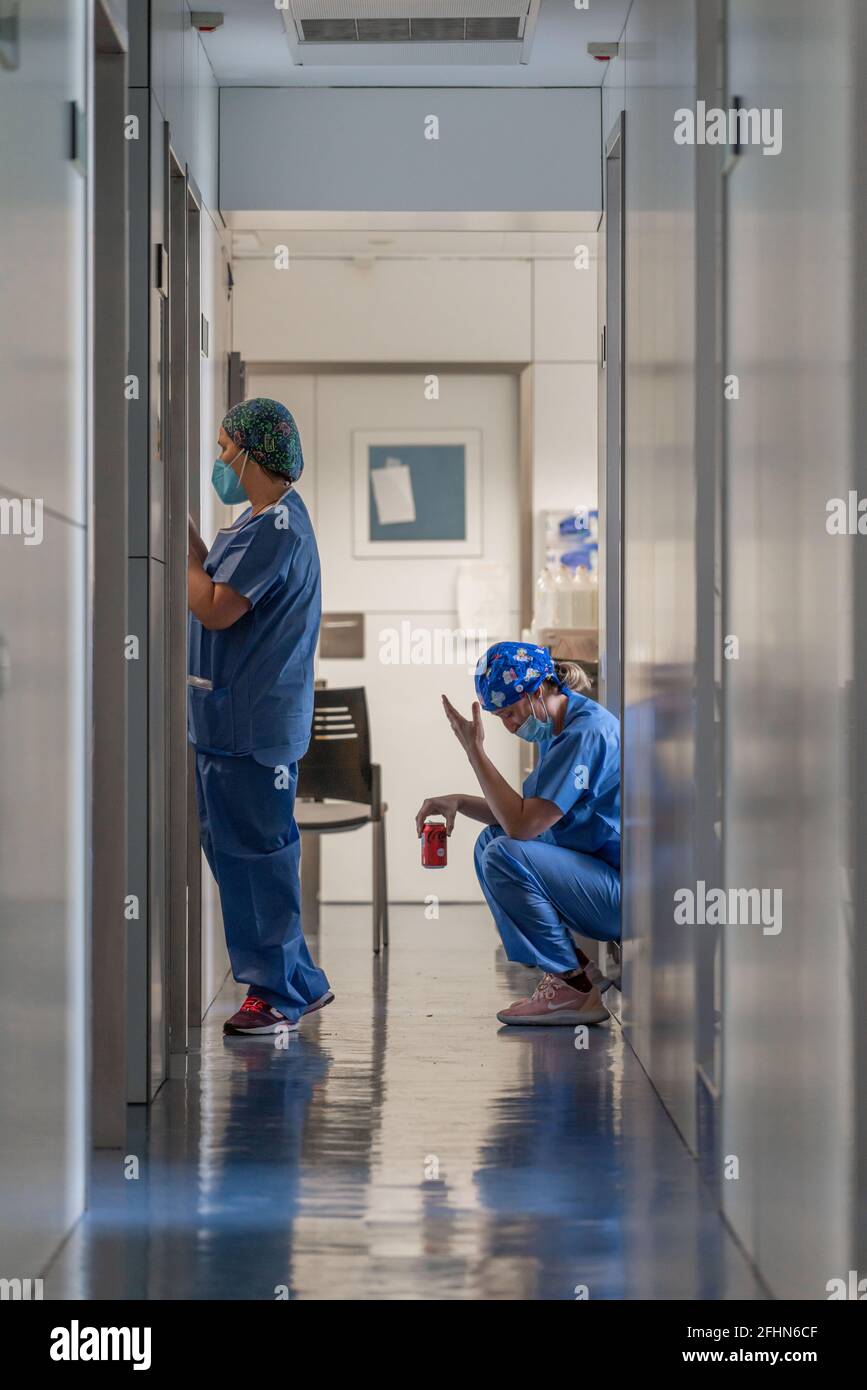 Un'infermiera prende una breve pausa durante il suo turno alla Clinica ospedaliera di Barcellona.Barcellona è stata una delle città in Europa che ha visto il suo sistema sanitario crollare più a causa di gravi casi di Covid-19. Qui, nell'unità di terapia intensiva della Clinica ospedaliera, la normalità sta gradualmente ritornando man mano che la pandemia viene portata sotto controllo. Anche se i pazienti più gravi di Covid, la maggior parte dei quali non possono respirare da soli, sono ancora in trattamento qui, mentre la pressione sul personale sanitario è in qualche modo sopportabile. Il Ministero della Salute della Spagna ha registrato un totale di 3.47 milioni di infezioni e 77,591 morti dal Foto Stock