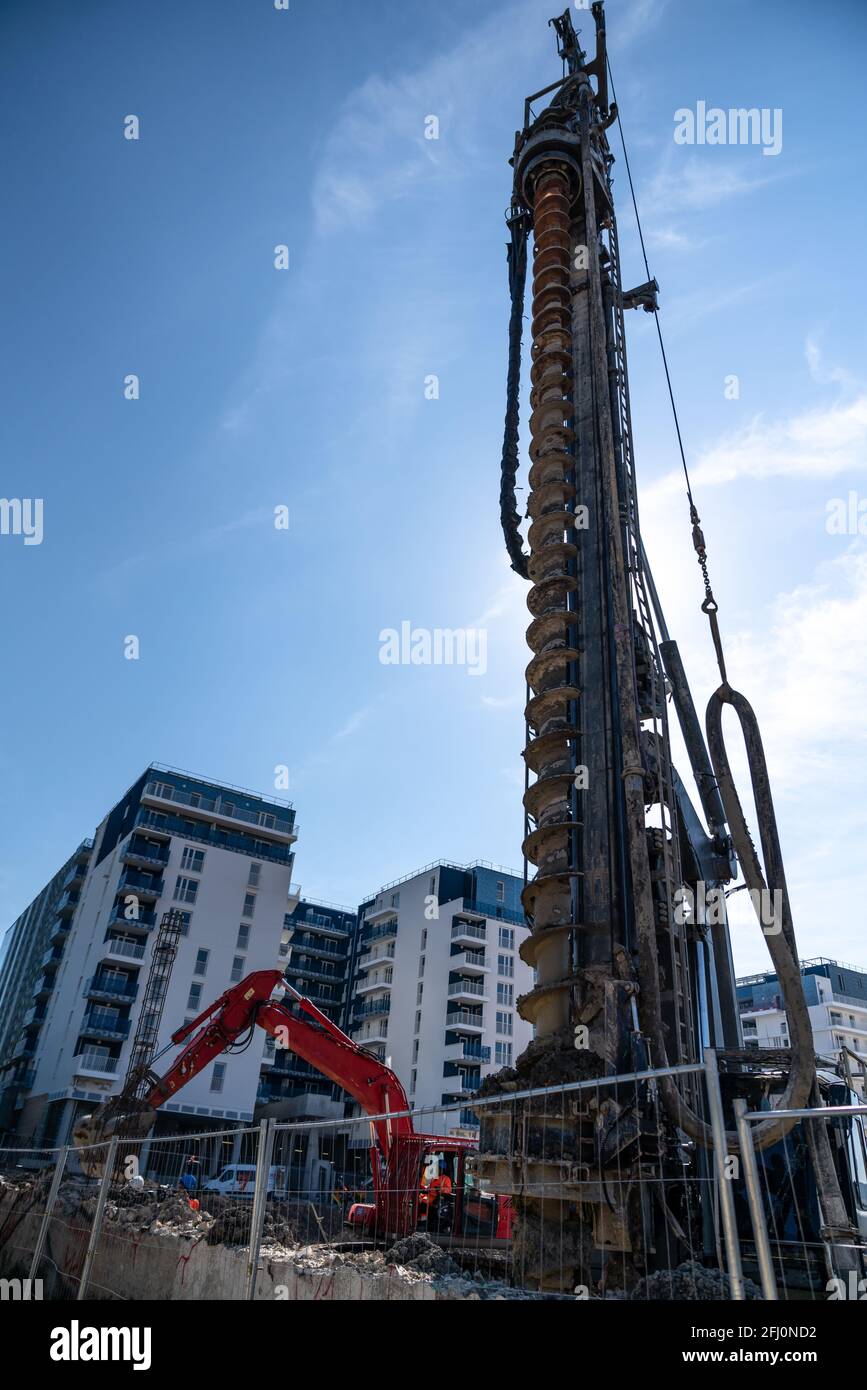 Escavatore in cantiere - progetto immobiliare di grandi dimensioni in città Foto Stock