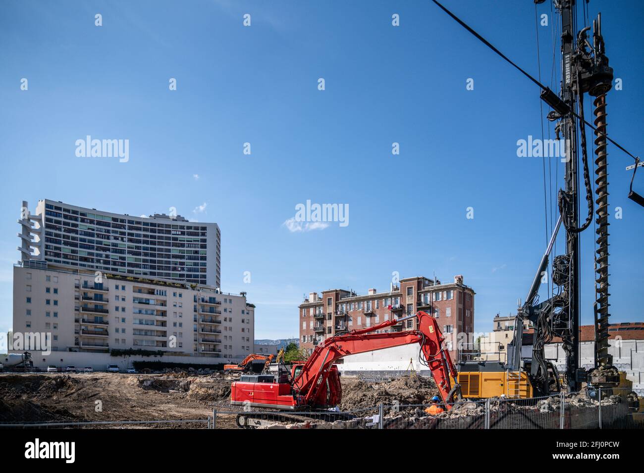 Escavatore in cantiere - progetto immobiliare di grandi dimensioni in città Foto Stock