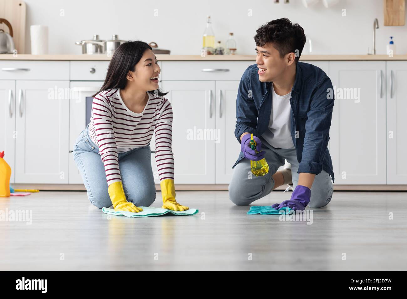 Giovane coppia asiatica piano di pulizia in cucina e parlare Foto Stock