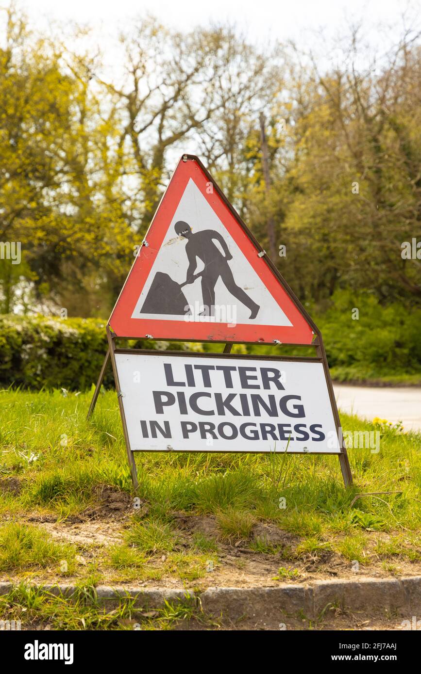 Cartello di avvertimento uomini al lavoro con raccolta rifiuti in corso sotto di esso. Perry Green, Hertfordshire. REGNO UNITO Foto Stock