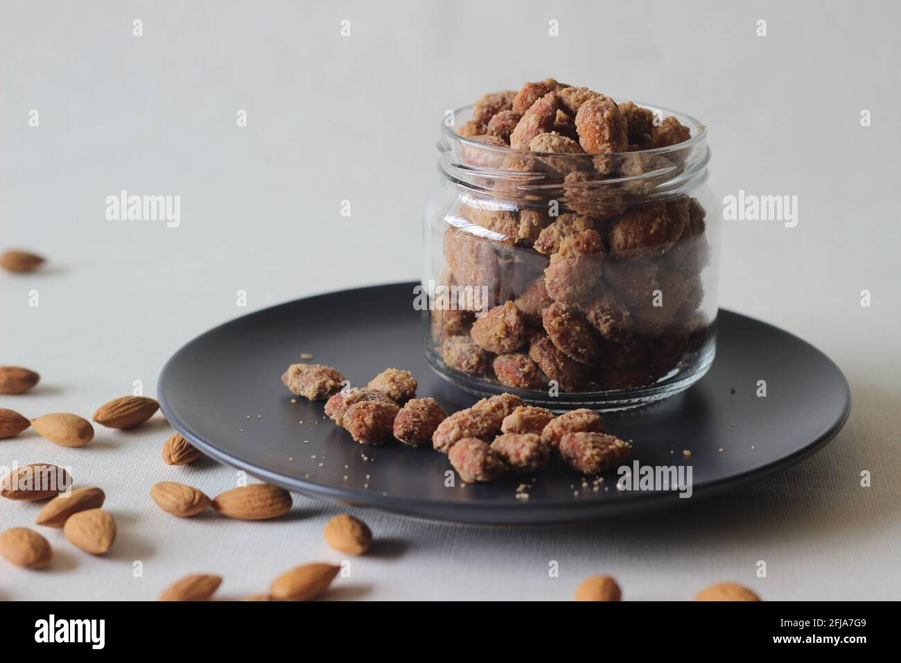 Mandorle candite croccanti e dorate. Scatto su sfondo bianco. Foto Stock