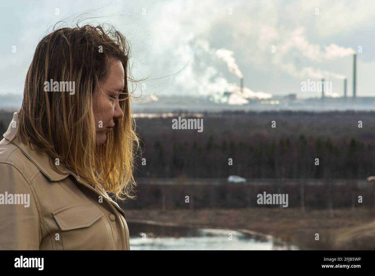 Inquinamento atmosferico polpa e cartiera e triste donna in primo piano. Foto Stock