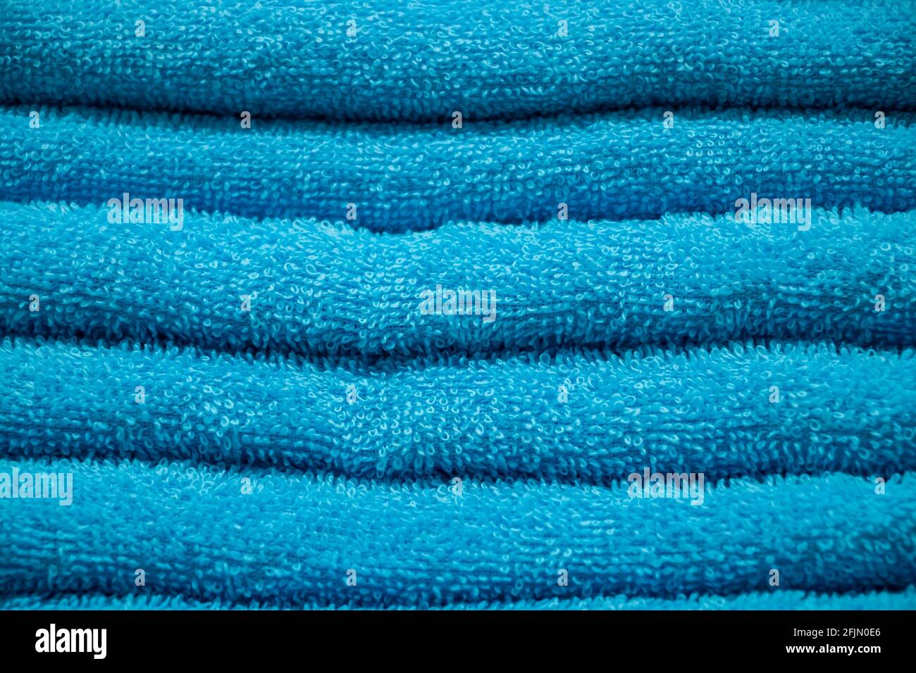 Texture di spugna blu primo piano asciugamano. Una pila di accessori per bagno morbidi. Foto Stock