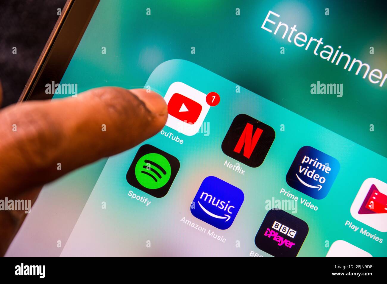 Dito maschile adulto che punta l'applicazione youtube sul dispositivo digitale personale Foto Stock