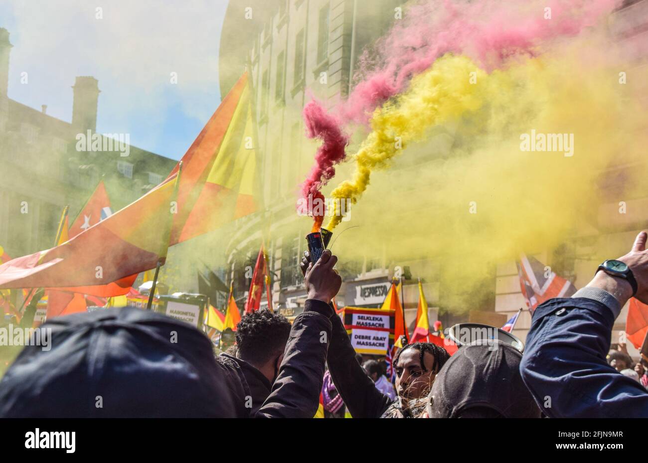 Londra, Regno Unito. 25 Apr 2021. I manifestanti trattengono i fumi durante la dimostrazione. Migliaia di persone hanno marciato nel centro di Londra per protestare contro quella che i manifestanti chiamano la "guerra genocida" dell'Etiopia e dell'Eritrea sulla regione del Tigray. Credit: SOPA Images Limited/Alamy Live News Foto Stock