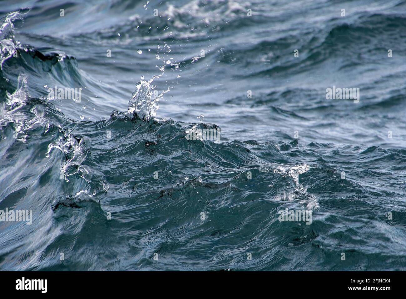 Primo piano di acqua ondulata del lago con gocce di spruzzo Foto Stock