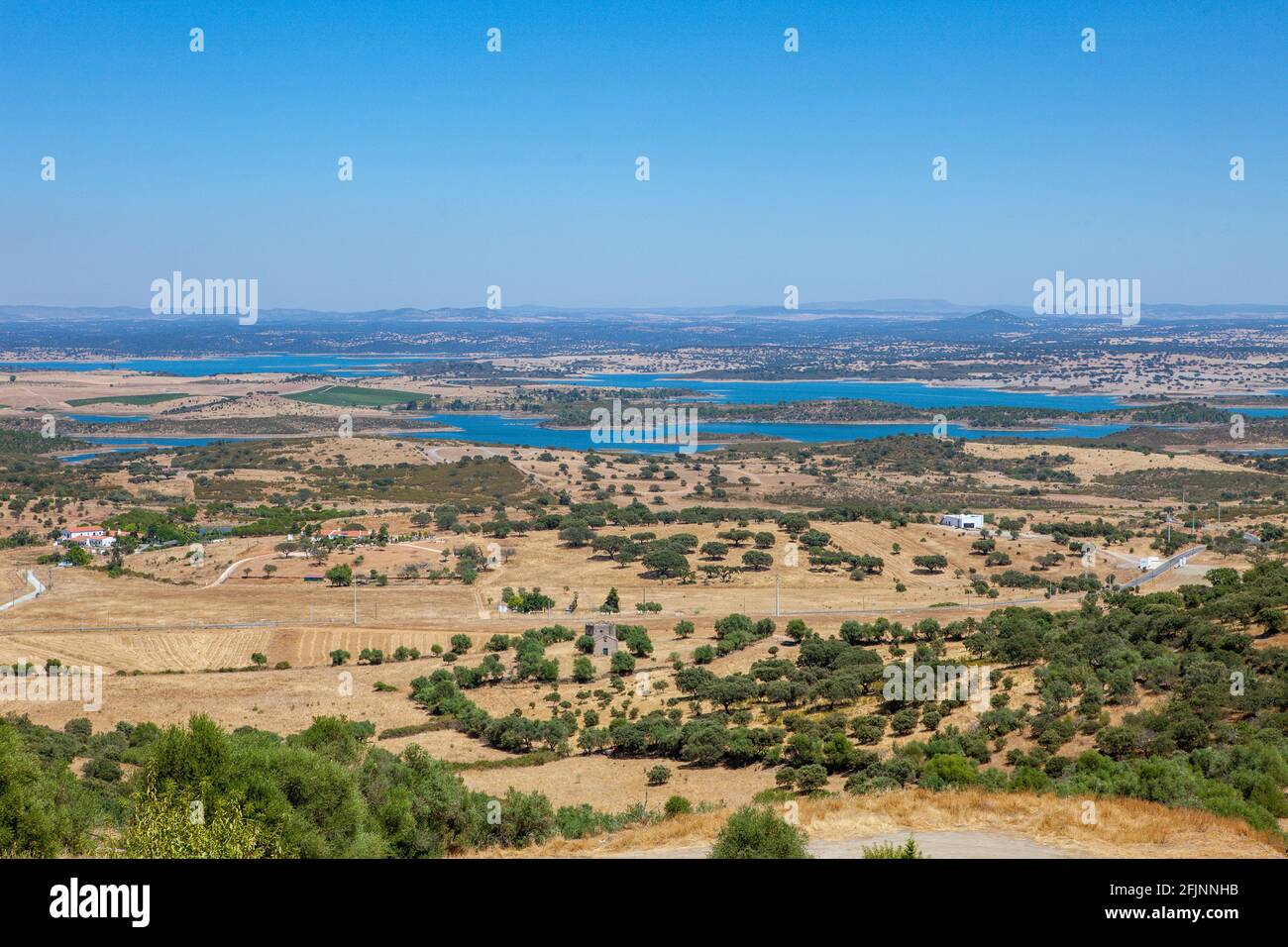 Vista sulla diga di Alqueva, il più grande lago artificiale d'Europa, vista dal villaggio collinare di Monsaraz nella regione dell'Alentejo, in Portogallo Foto Stock