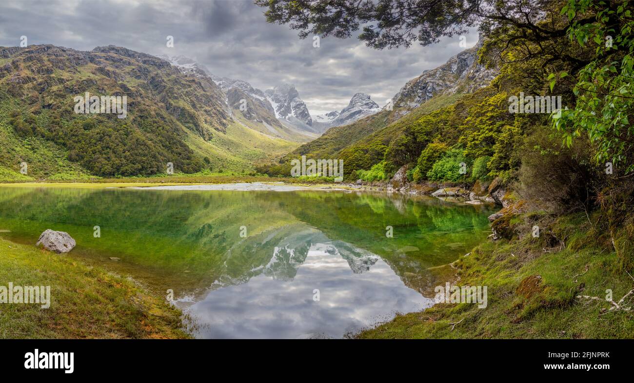 Tranquillo lago di montagna Mackenzie presso il famoso Routeburn Track, Fiordland National Park, Isola del Sud della Nuova Zelanda Foto Stock
