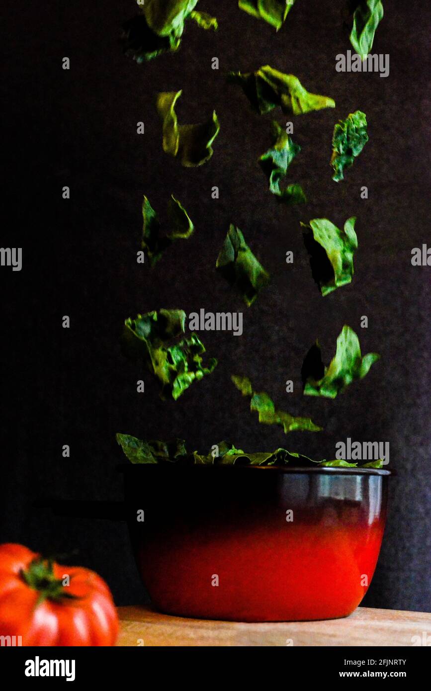Foglie di spinaci che cadono in una pentola Foto Stock