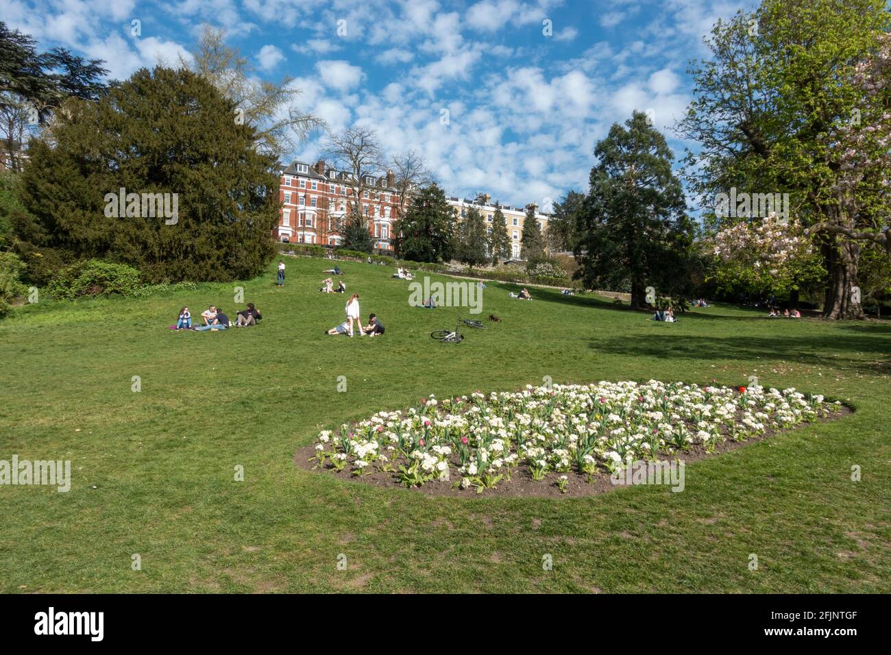 Vista delle persone che godono del sole primaverile su Terrace Fields guardando verso Richmond Hill, Richmond, UK. Foto Stock