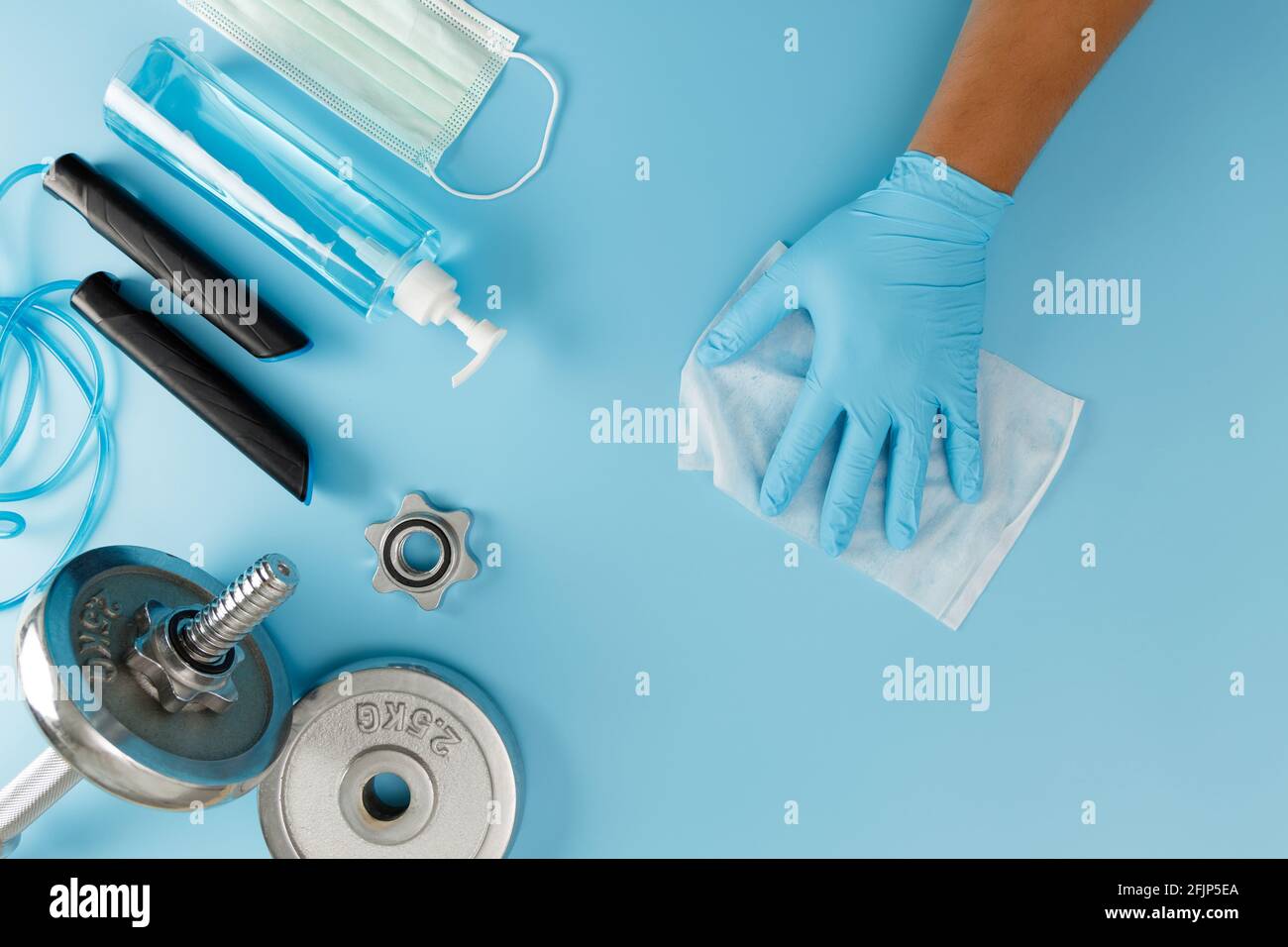 Fitness pulizia palestra Covid 19 virus con alcool spray anti Virus concetto di allenamento da casa rimanere al sicuro Foto Stock