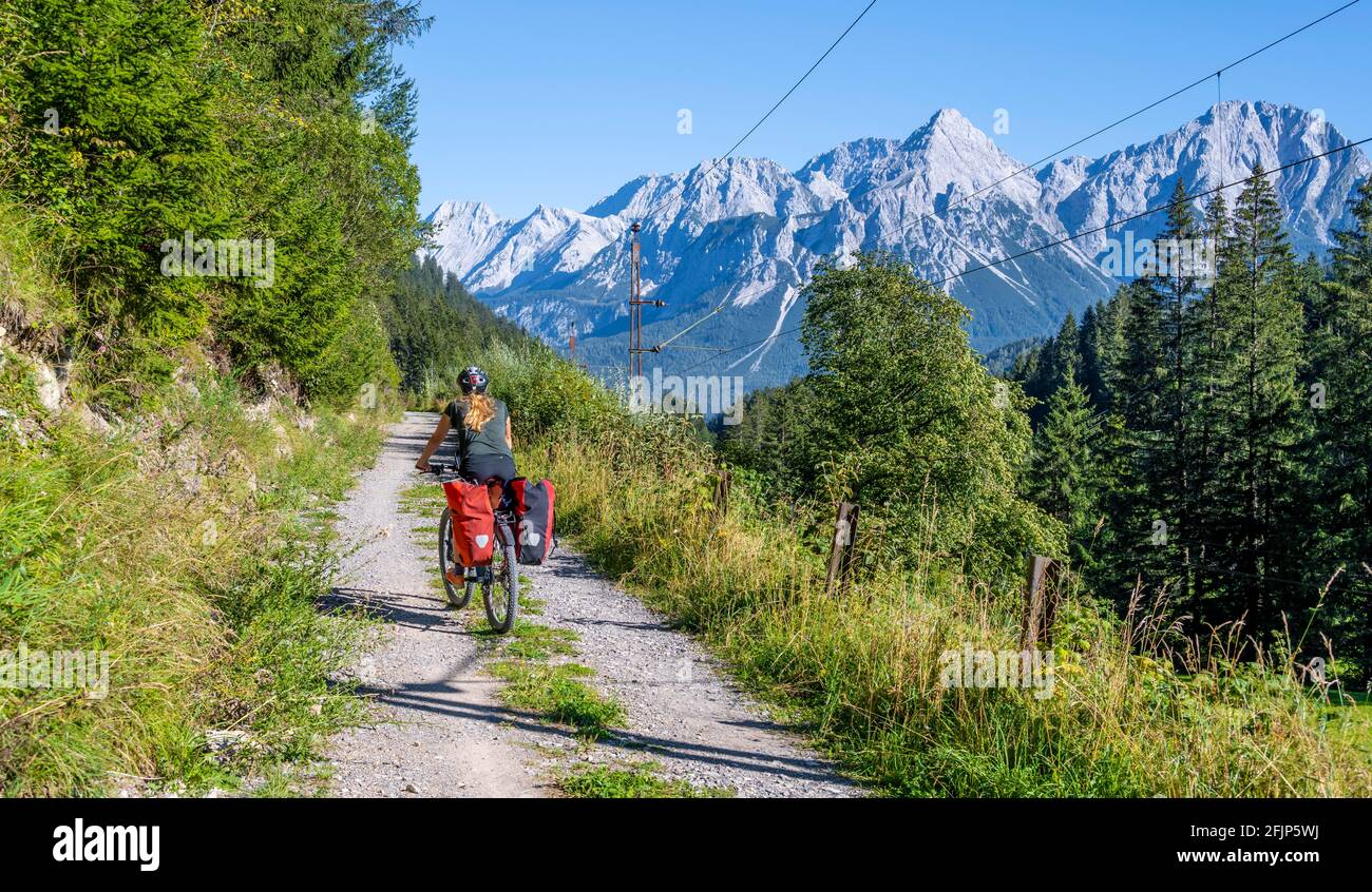 Ciclista in bicicletta con mountain bike, sulla pista ciclabile Via Claudia Augusta, dietro Ehrwalder Sonnenspitze, Ehrwalder Becken, nei pressi di Ehrwald, Tirolo Foto Stock