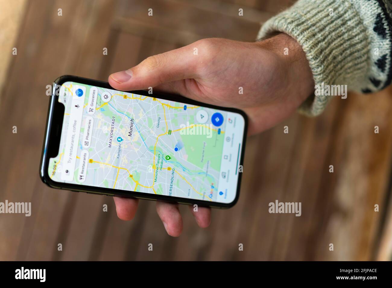 Hand haelt iPhone 11 Pro mit Google Maps App, Online Karten Dienst, Bildschirmfoto, smartphone Foto Stock