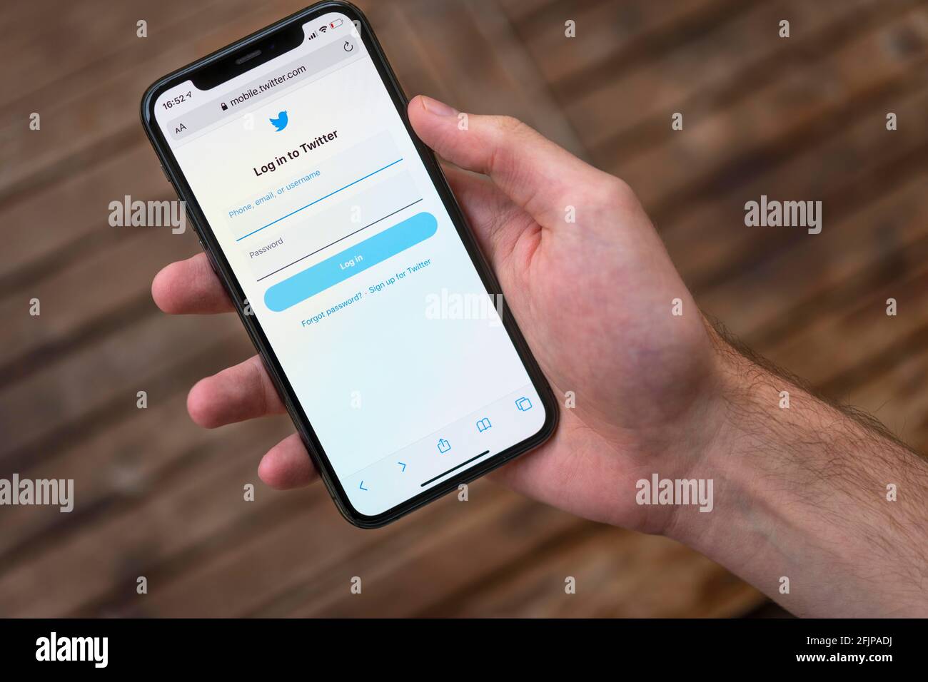 Hand haelt iPhone 11 Pro mit geoeffneter Twitter Website, Login, Soziales Netzwerk, Logo, smartphone Foto Stock