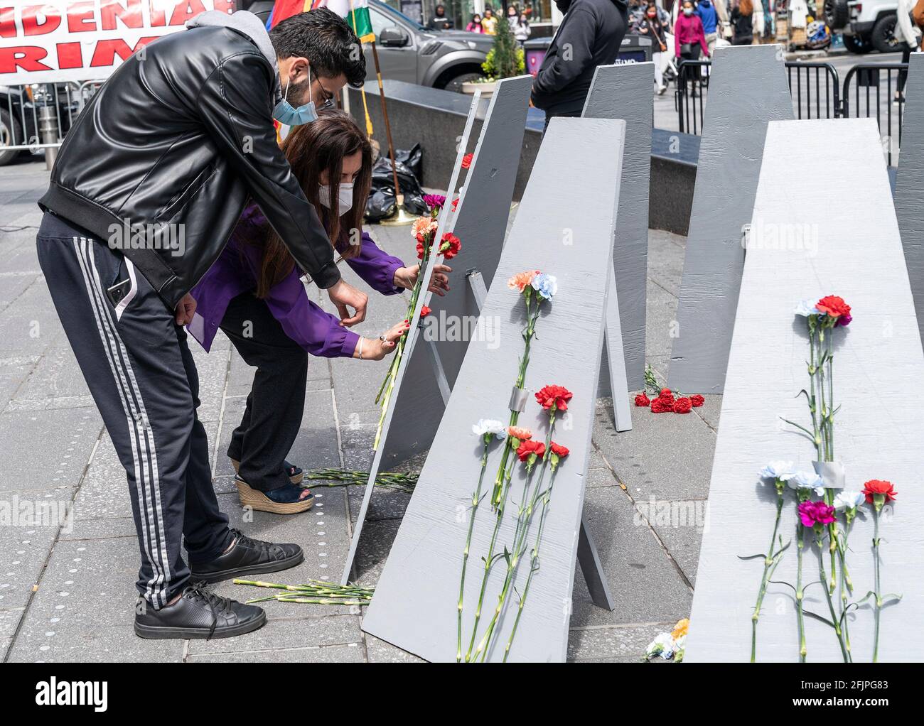 La gente si raduna su Times Square per commemorare il 106esimo anniversario del genocidio armeno da parte dell'Impero Ottomano. A causa della pandemia di COVID-19, il rally è stato limitato a 50 partecipanti e non vi sono stati discorsi dal vivo da parte di politici che hanno inviato le loro osservazioni scritte per essere letti durante l'evento. La gente ha anche celebrato il riconoscimento del genocidio armeno da parte del presidente Joe Biden per la prima volta nella storia americana da parte di qualsiasi presidente. Una coppia allega fiori al memoriale realizzato al rally. (Foto di Lev Radin/Pacific Press) Foto Stock
