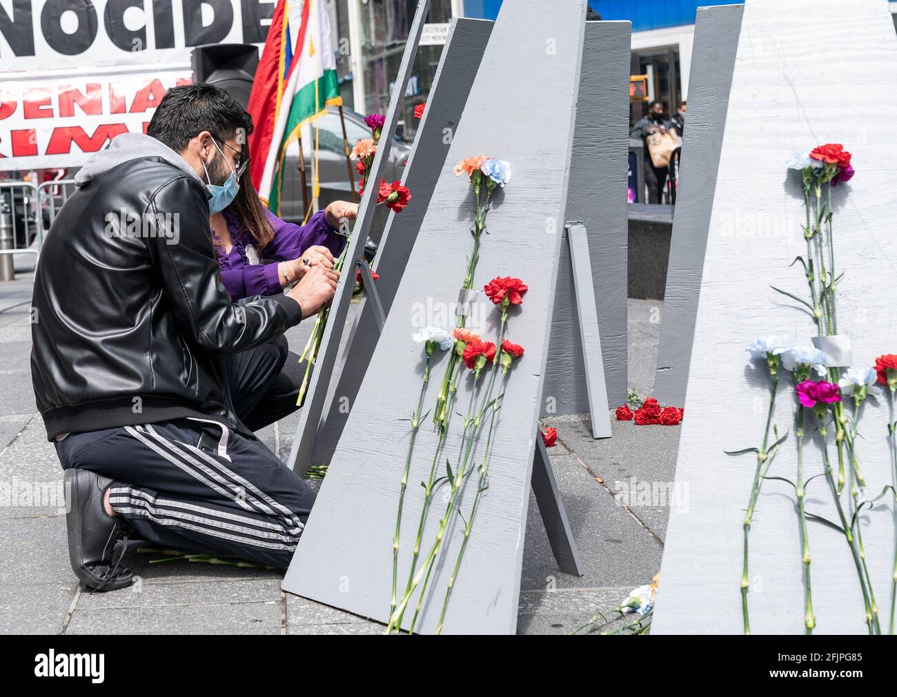 La gente si raduna su Times Square per commemorare il 106esimo anniversario del genocidio armeno da parte dell'Impero Ottomano. A causa della pandemia di COVID-19, il rally è stato limitato a 50 partecipanti e non vi sono stati discorsi dal vivo da parte di politici che hanno inviato le loro osservazioni scritte per essere letti durante l'evento. La gente ha anche celebrato il riconoscimento del genocidio armeno da parte del presidente Joe Biden per la prima volta nella storia americana da parte di qualsiasi presidente. Una coppia allega fiori al memoriale realizzato al rally. (Foto di Lev Radin/Pacific Press) Foto Stock