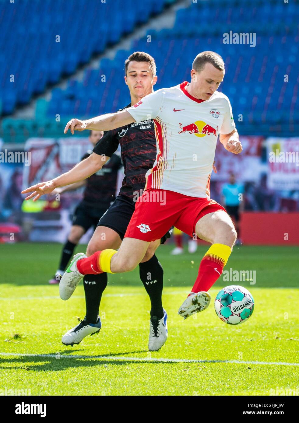 Lipsia, Germania. 25 Apr 2021. Lukas Klostermann (R) di Lipsia controlla la palla sotto la difesa di Marc Oliver Kempf di Stoccarda durante una partita tedesca della Bundesliga tra RB Lipsia e VfB Stuttgart a Lipsia, Germania, 25 aprile 2021. Credit: Kevin Voigt/Xinhua/Alamy Live News Foto Stock