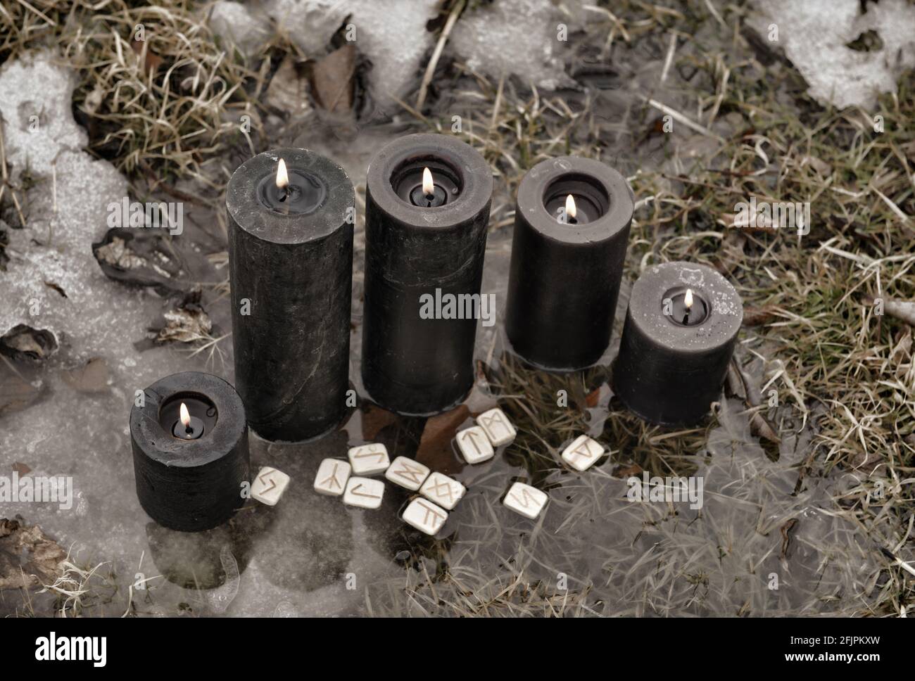 Grunge ancora vita con candele nere e rune in acqua fuori. Sfondo esoterico, gotico e occulto, Halloween mistico e wicca concetto all'aperto. Foto Stock