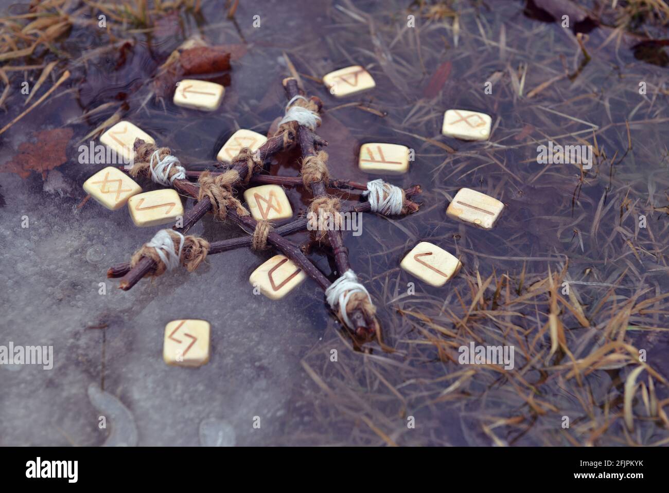 Rituale magico con rune di legno e pentagramma in acqua. Sfondo esoterico, gotico e occulto, Halloween mistico e wicca concetto all'aperto. Foto Stock