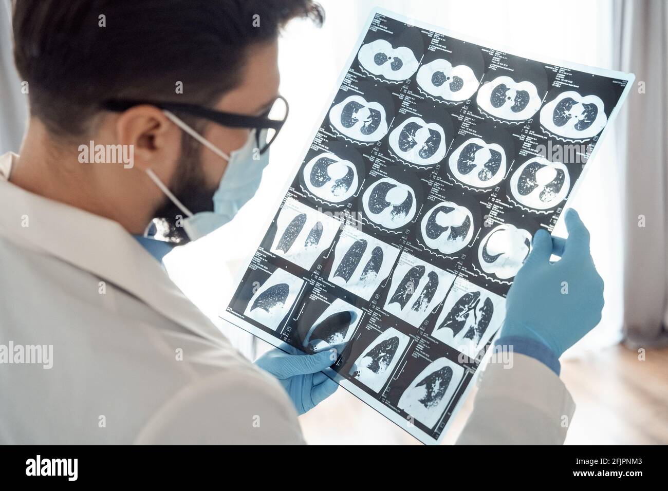 Covid-19 scannerizzare il corpo con la mano del medico maschile indossando guanti primo piano Foto Stock