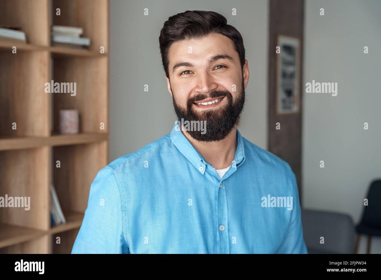 Sorridente millenario uomo caucasico freelance in ufficio headshot ritratto Foto Stock