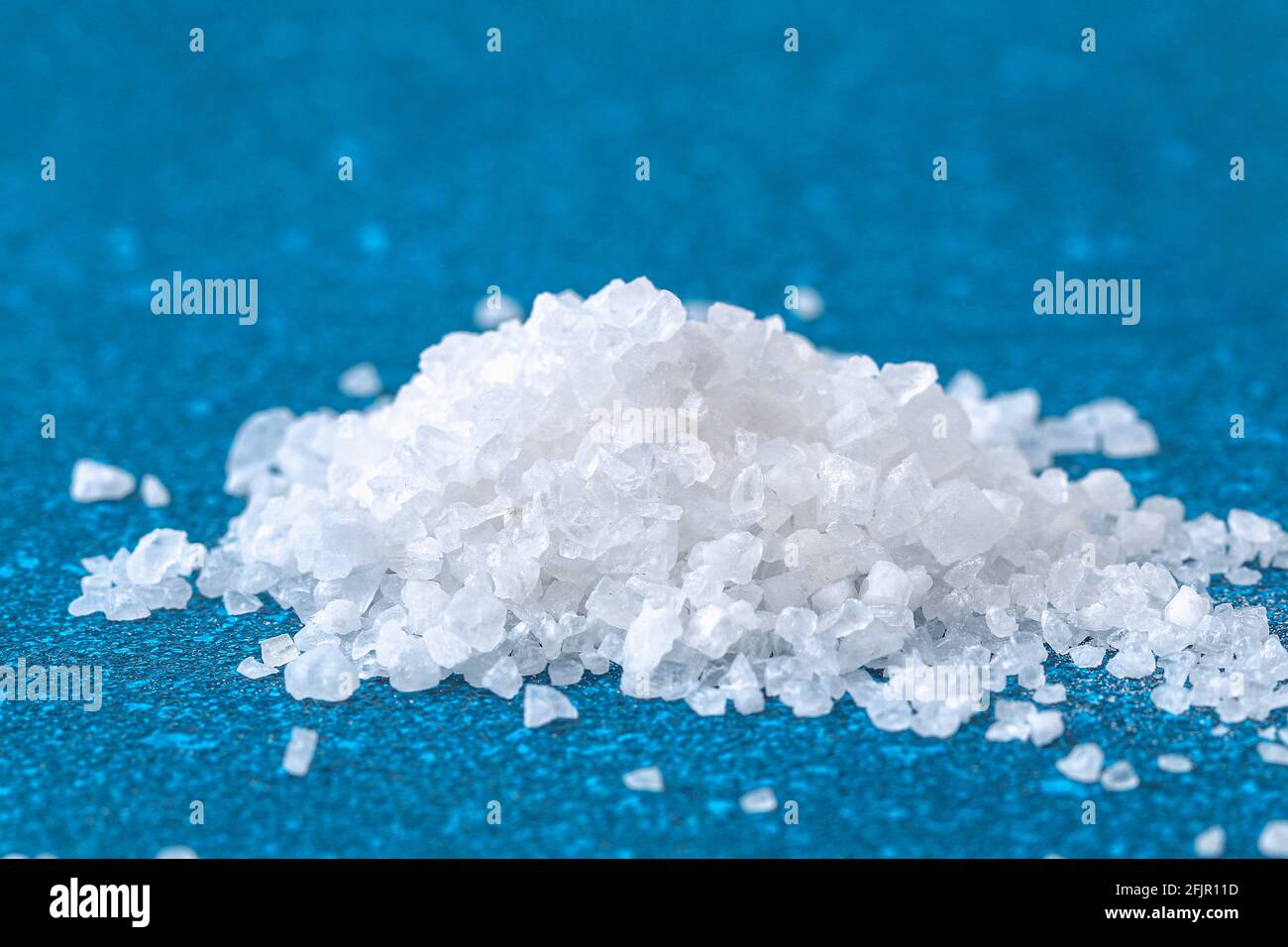 Cristalli di sale grossolano su un tavolo blu. Sale di mare. Sfondo per la  pubblicità salato Foto stock - Alamy