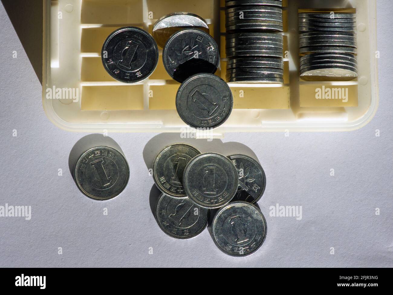Uno Yen sulla scatola delle monete, a fuoco basso. Concetto di risparmio di denaro, gestione di cassa Foto Stock