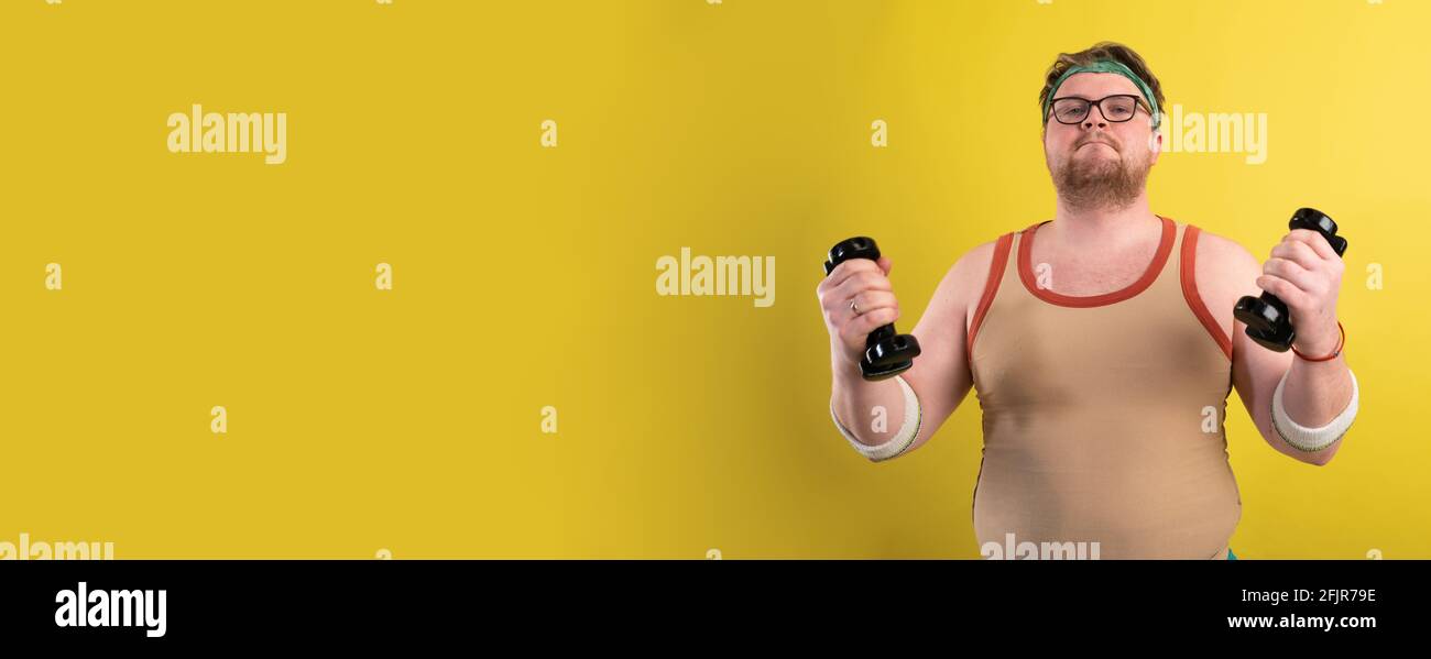 poster di promozione palestra. un uomo in sovrappeso che fa sport su uno sfondo giallo. Divertente uomo grasso Foto Stock