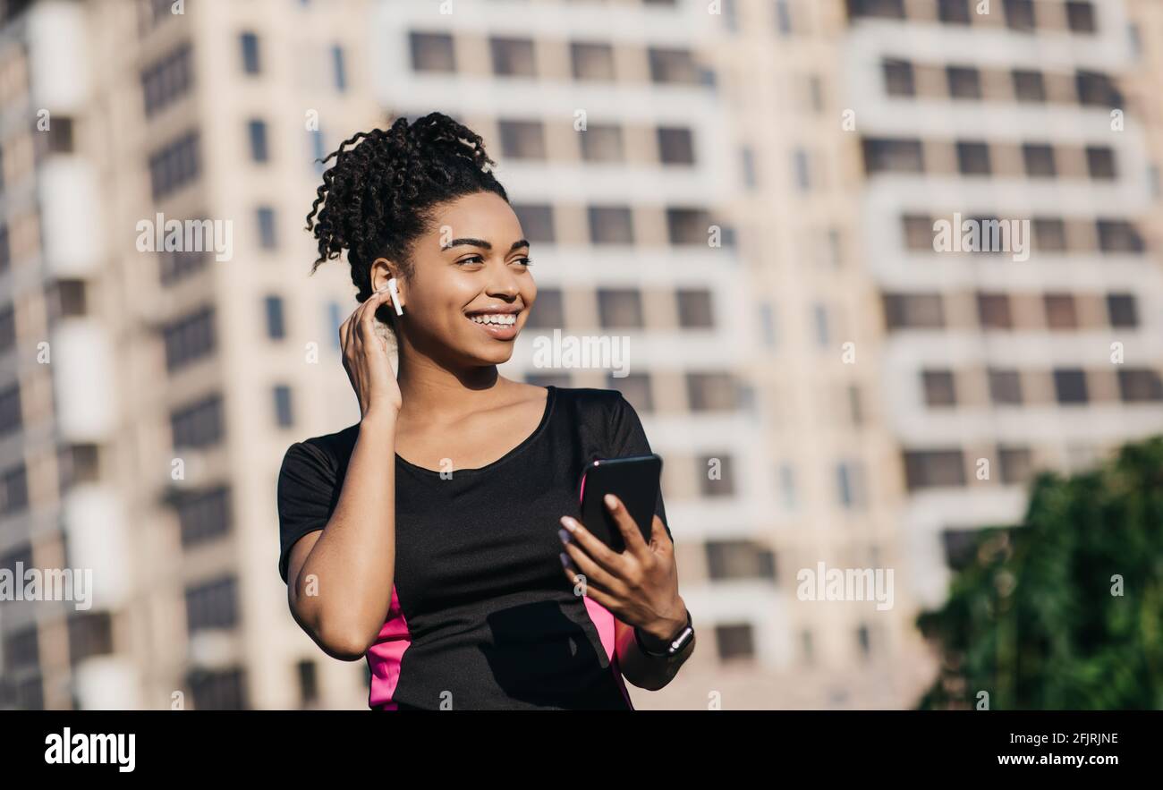 Dispositivi moderni, app mobile per lo sport e la musica in allenamento outdoor durante il covid-19 Foto Stock