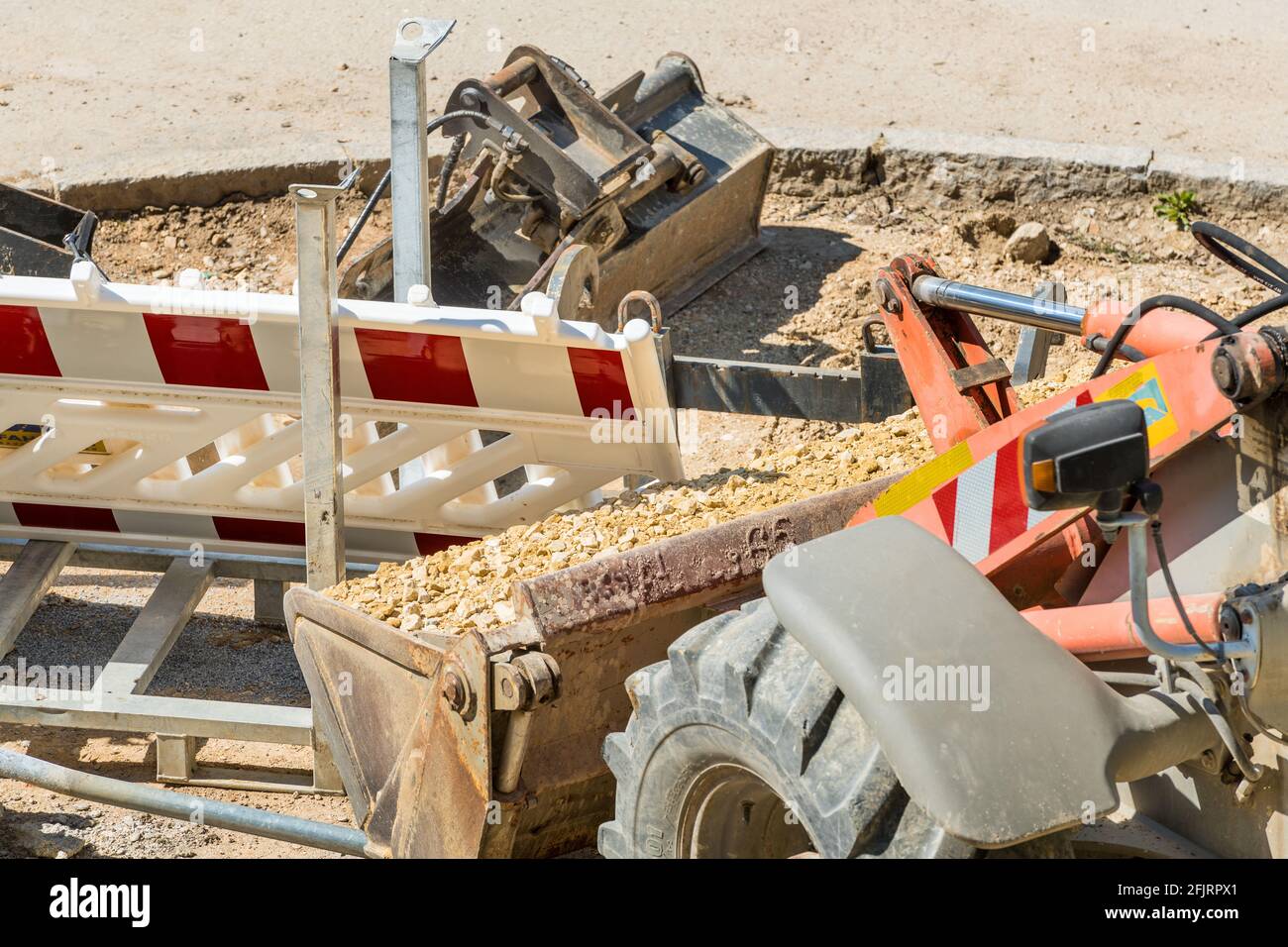 Cantiere stradale con escavatore e sabbia, lavori di costruzione di strade in corso Foto Stock