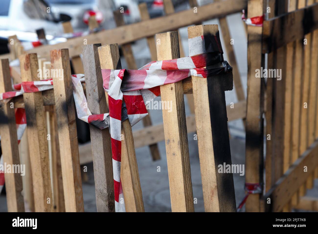 Foto di recinzione in legno con nastro adesivo sulla strada Foto Stock