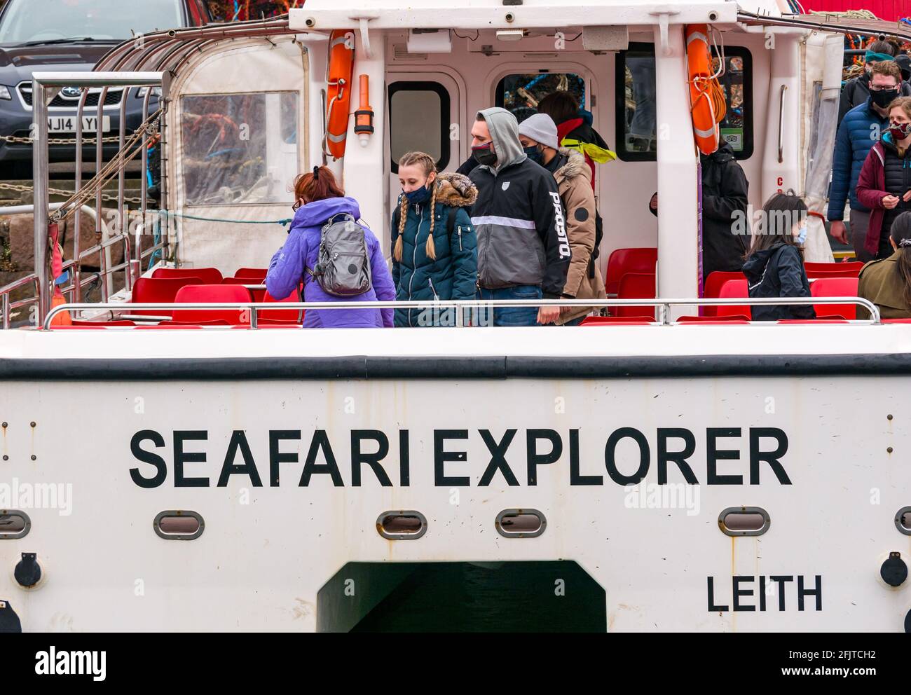 North Berwick, East Lothian, Scozia, Regno Unito, 26 aprile. Riaprire le aziende: Con le restrizioni di blocco attenuate oggi, lo Scottish Seabird Center prima gita turistica in barca da crociera si svolge dall'anno scorso. Nella foto: I passeggeri saliscono a bordo del catamarano SEAFARI Explorer indossando maschere facciali Foto Stock