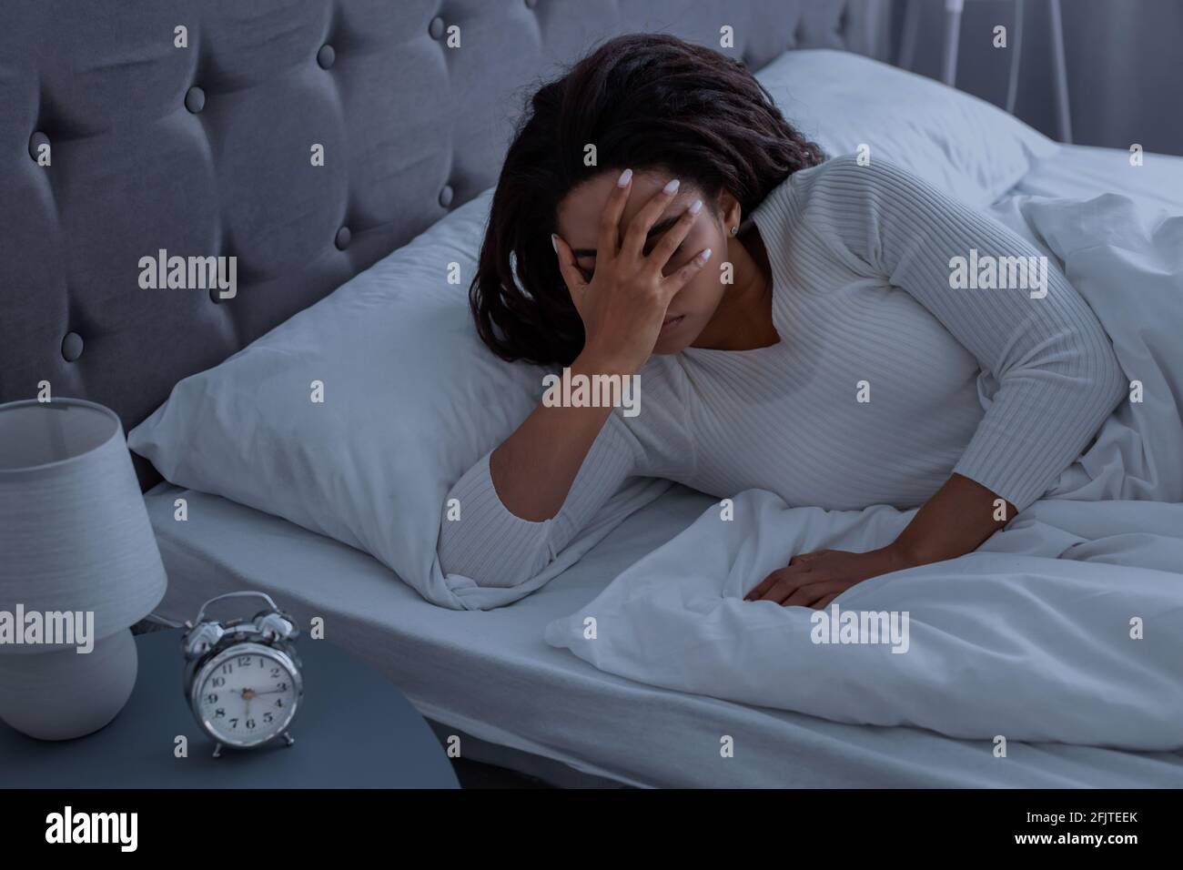 Donna nera che soffre di insonnia coprendo il viso Foto Stock