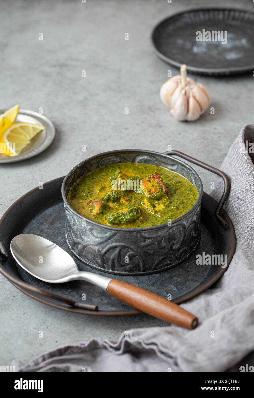 Piatto indiano Palak Paneer in ciotola su tavola di pietra grigia Foto Stock