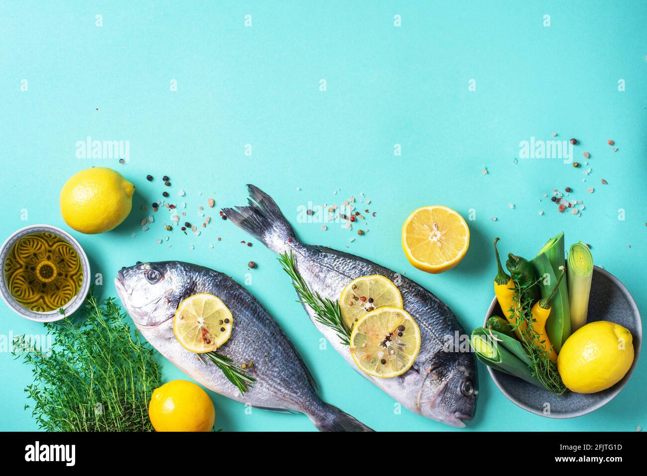 Pesce fresco di mare crudo dorado con fette di limone, erbe, olio, sale,  pepe, verdi su sfondo blu. Vista dall'alto. Concetto di cibo sano. Spazio  di copia. Cibo Foto stock - Alamy