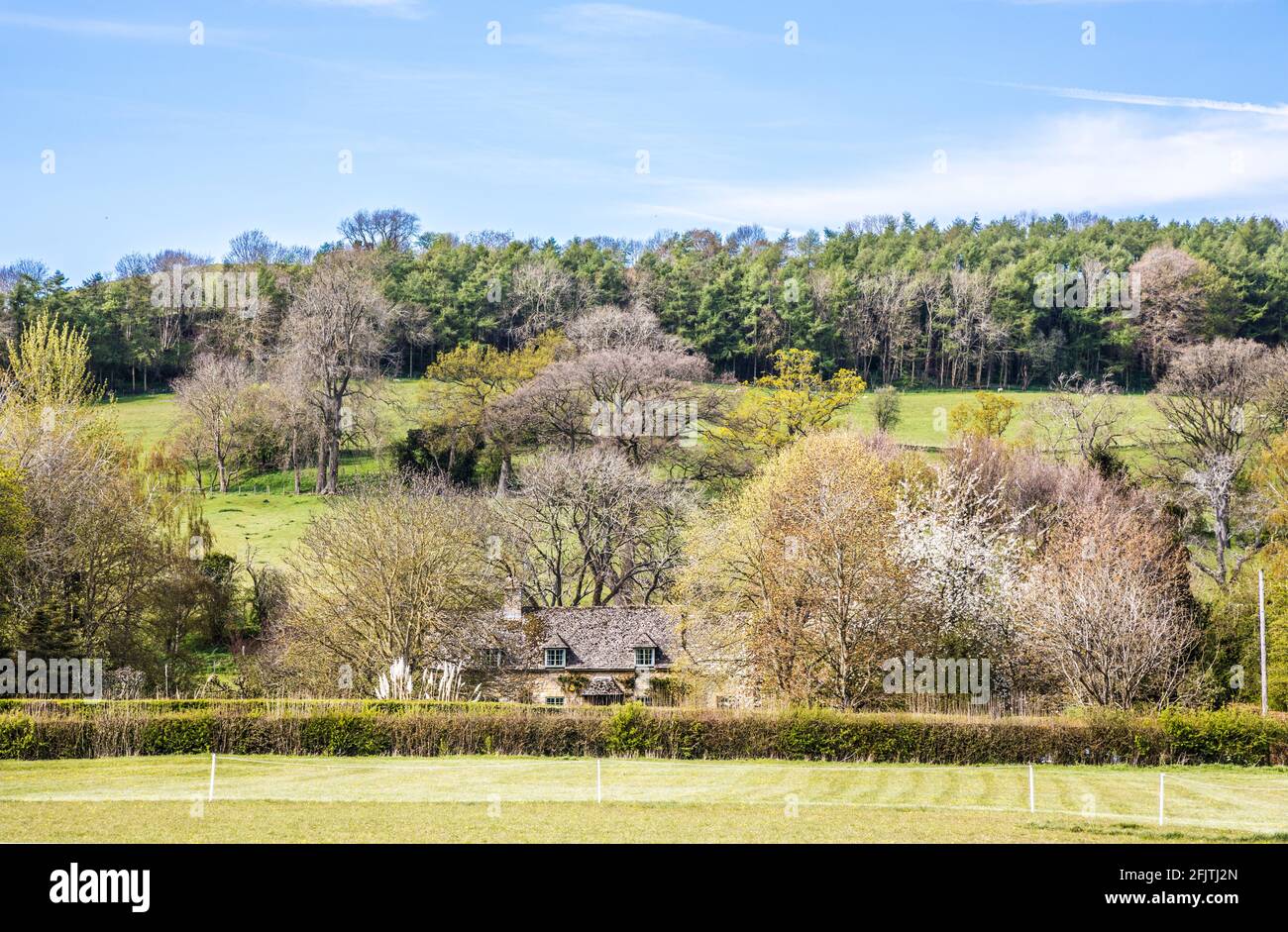Attraenti case in pietra poste tra la campagna ondulata del Cotswold. Foto Stock