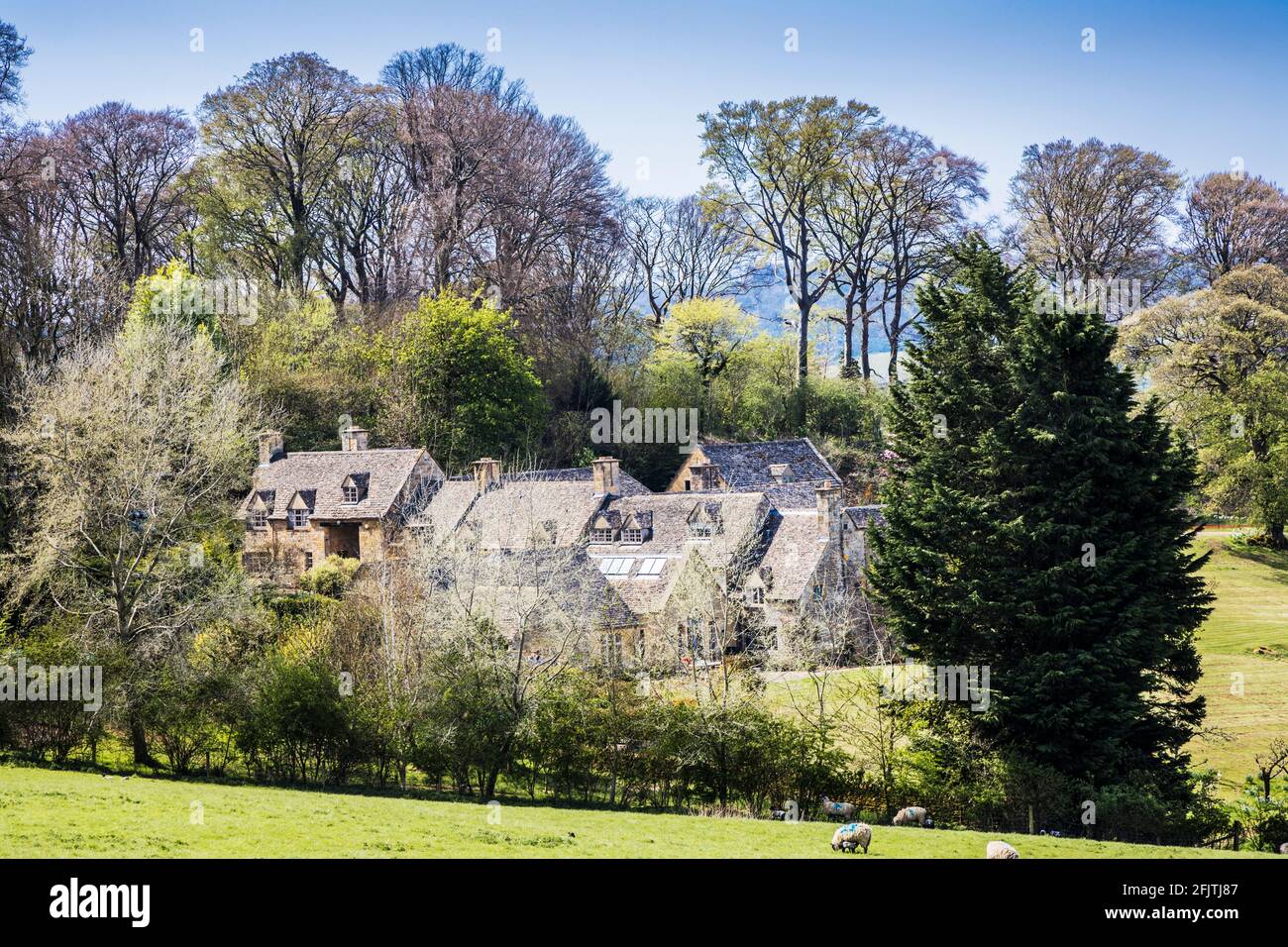 Attraenti case in pietra poste tra la campagna ondulata del Cotswold. Foto Stock