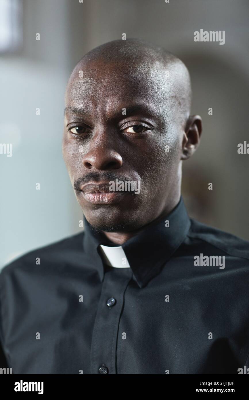 Ritratto del giovane sacerdote africano in colletto guardando la macchina fotografica Foto Stock