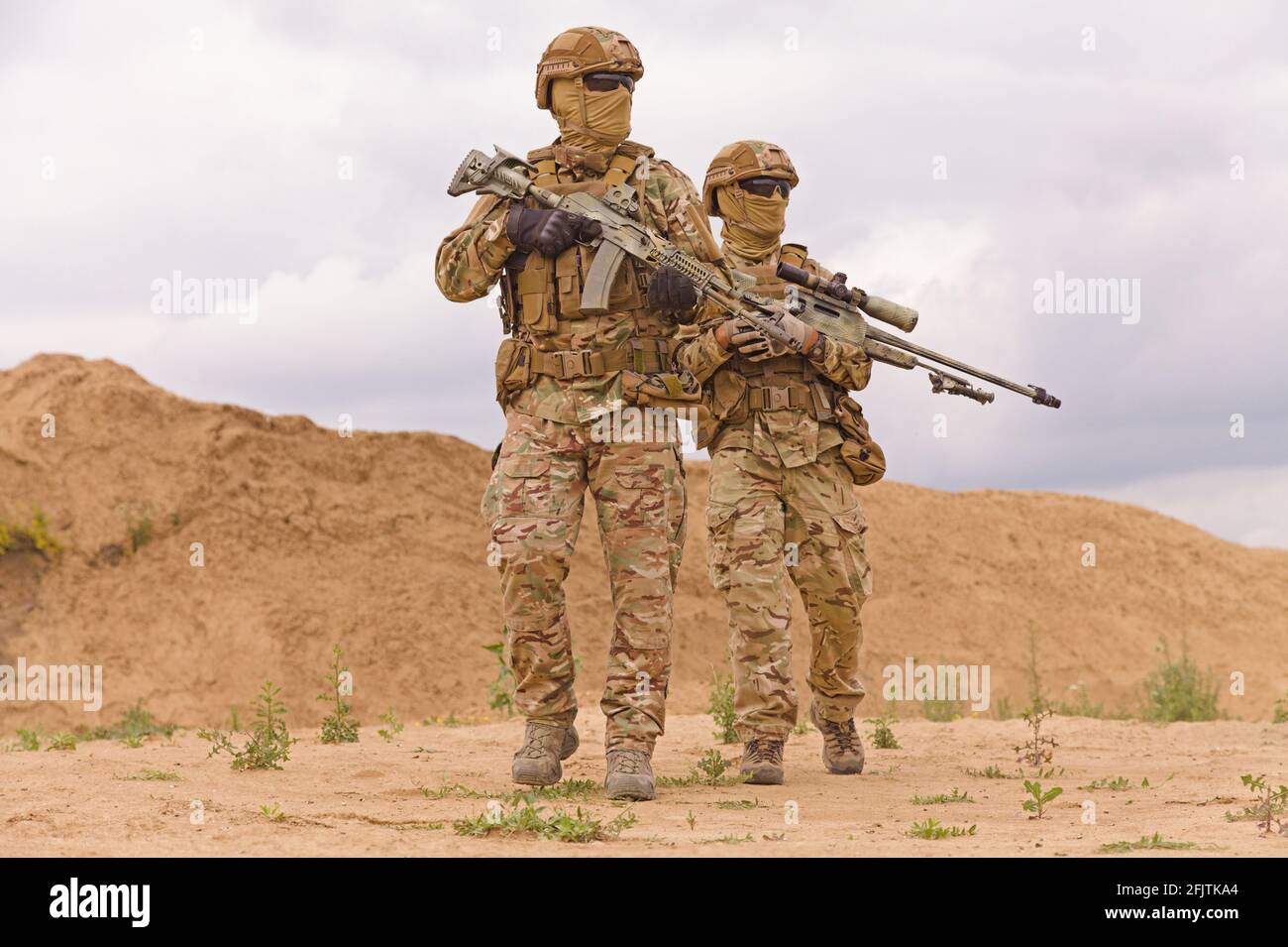 Soldati delle forze speciali attrezzati e armati nel deserto. Concetto di operazioni militari. Foto Stock