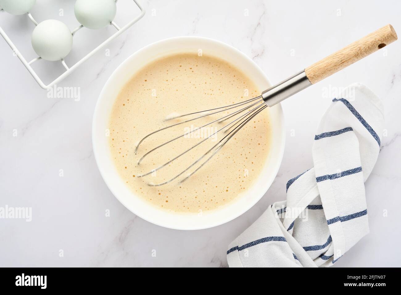 Preparazione di impasto per frittelle di casa per colazione o per Maslenitsa. Ingredienti sulla farina di grano da tavola, uova, burro, zucchero, sale, latte. Ricetta Foto Stock