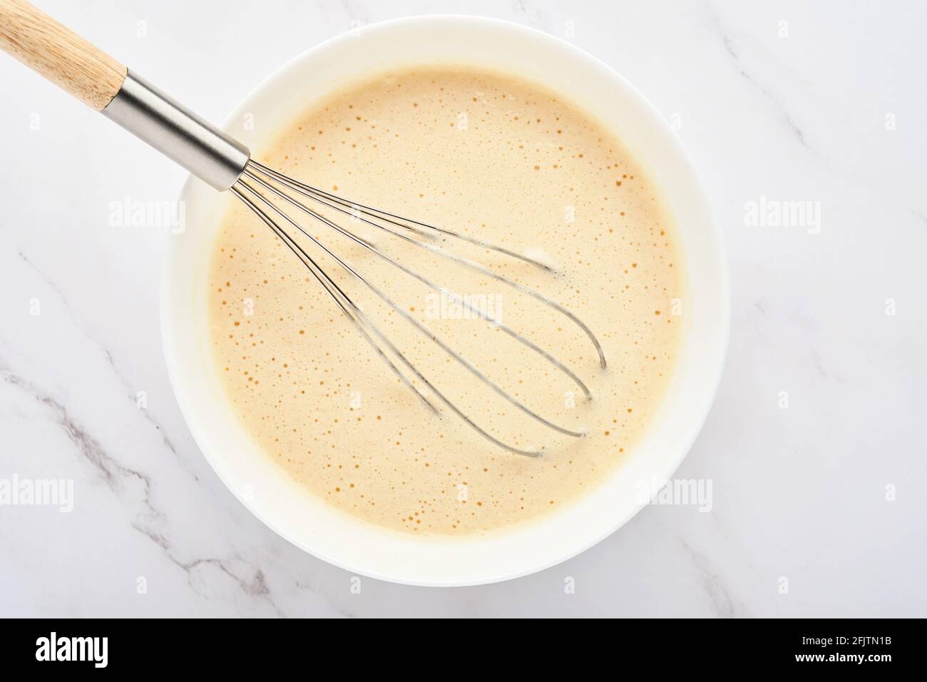 Preparazione di impasto per frittelle di casa per colazione o per Maslenitsa. Ingredienti sulla farina di grano da tavola, uova, burro, zucchero, sale, latte. Ricetta Foto Stock