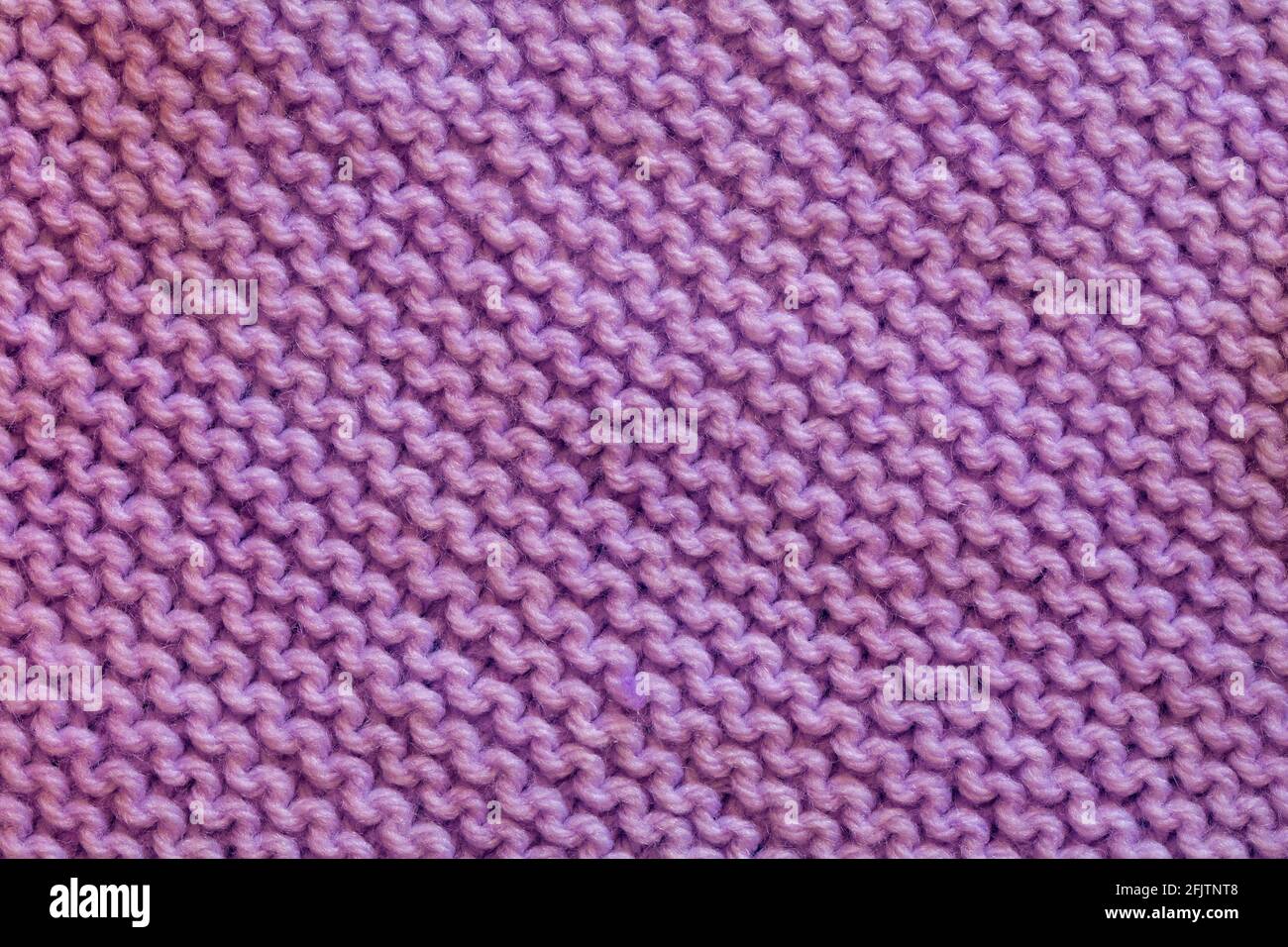 primo piano del quadrato in maglia rosa viola per cucire insieme per fare una coperta Foto Stock