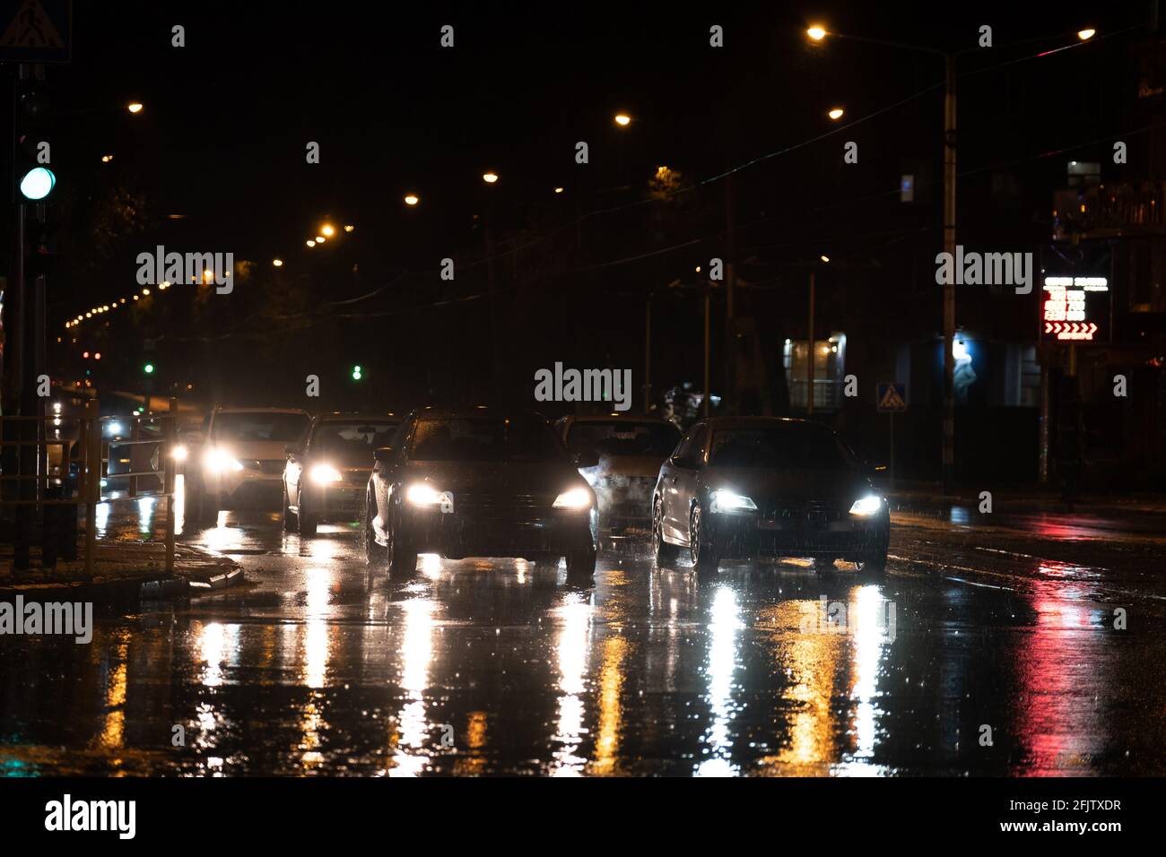 traffico notturno in città. La pioggia dura cade di notte con auto poco nitide. Foto Stock