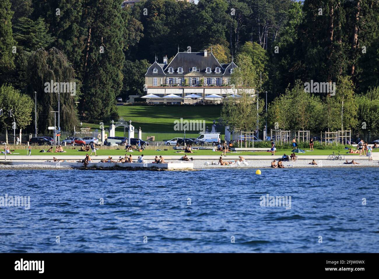 Svizzera, Cantone di Ginevra, Ginevra, Eaux Vives spiaggia sulle rive del lago Leman, hotel du Parc des Eaux Vives sullo sfondo Foto Stock