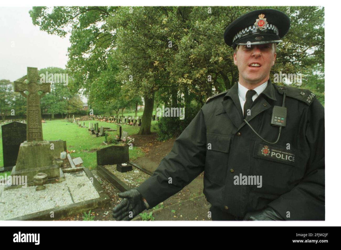Un poliziotto a Hyde Cimitero che protegge la zona dove un il corpo è stato esumato nelle prime ore del La polizia di mattina sta investigando il Dott. Harold Shipman che è accusato di uccidere 15 dei suoi paitents Foto Stock