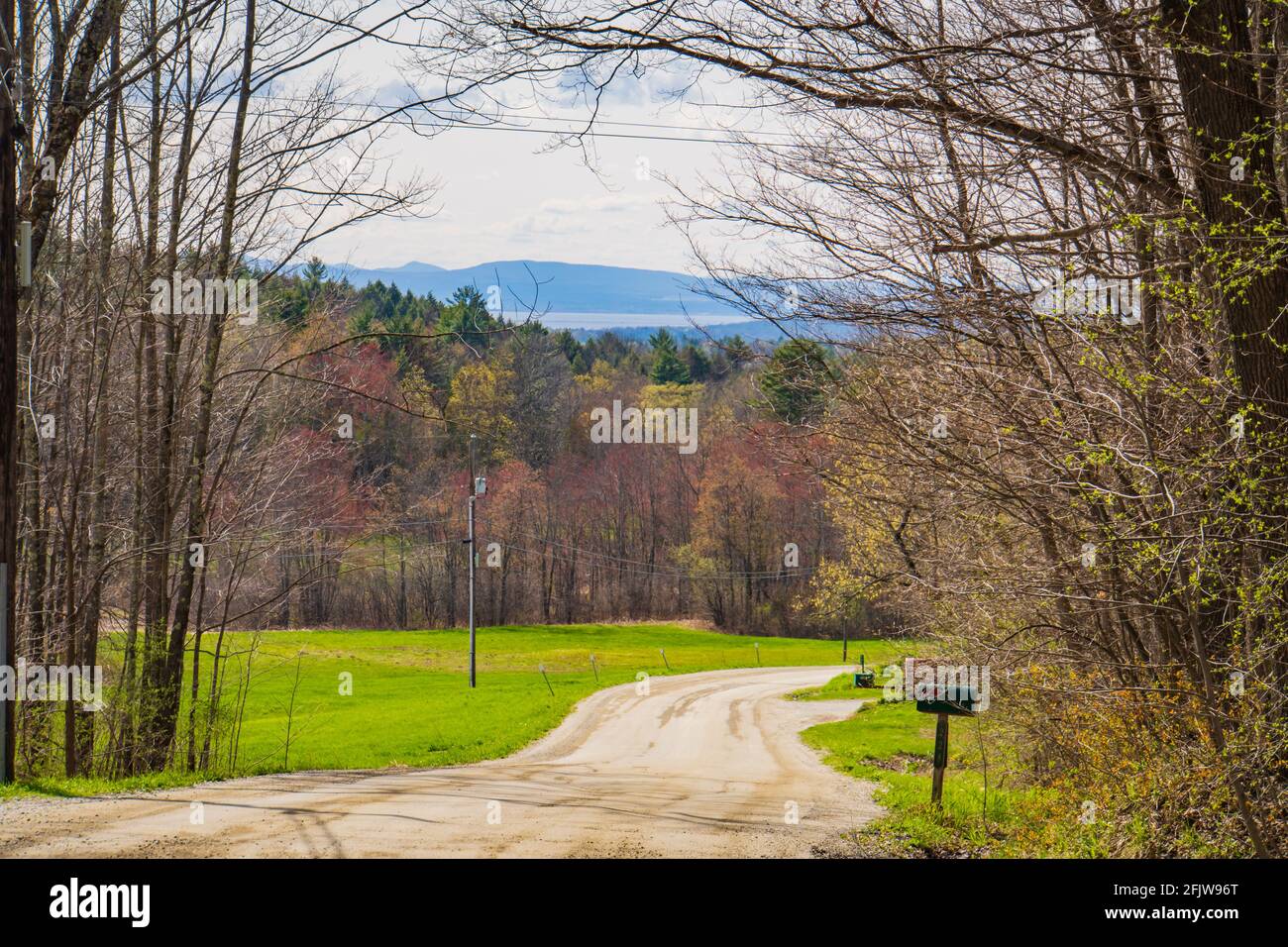 Tortuosa strada sterrata nella campagna del Vermont con vista sul lago Champlain e le montagne Adirondack a New York Foto Stock