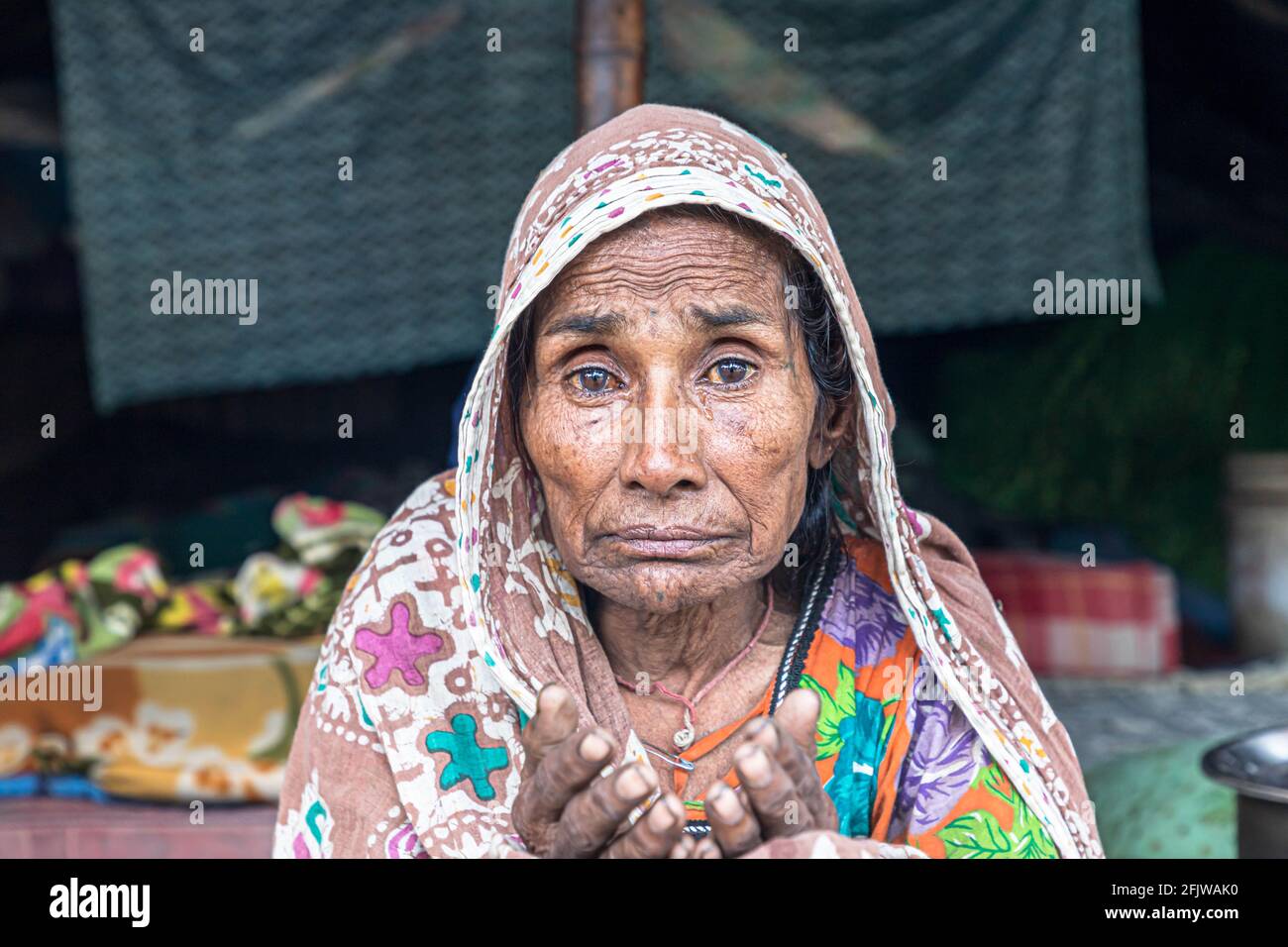 ritratto della donna anziana indiana che mendica su strada durante il blocco in india. Foto Stock