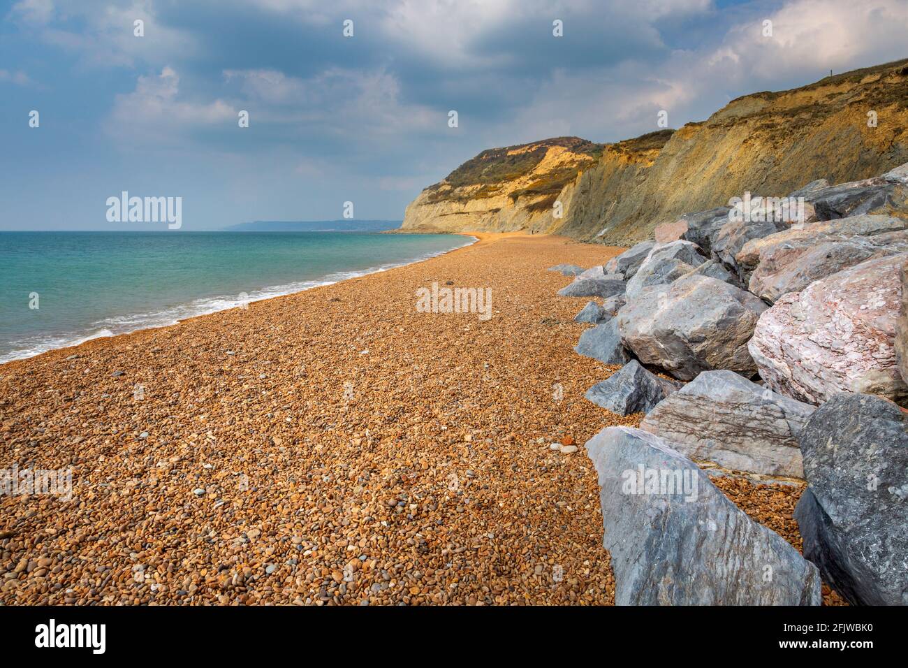 Golden Cap lungo la spiaggia di ciottoli a Seatown, Dorset, Inghilterra Foto Stock