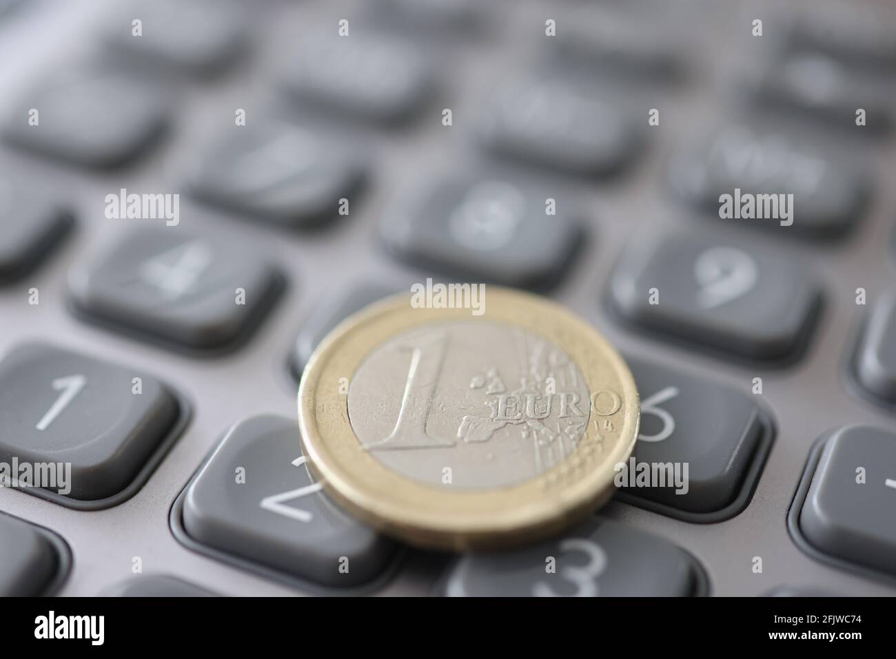 Una moneta di euro è sulla calcolatrice closeup Foto Stock